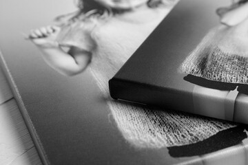 Detailed close-up of black and white canvas prints featuring a joyful child, stretched on wooden...