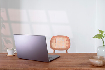 Laptop notebook on wooden table, cozy workspace in living room.