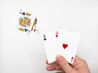 White male hand showing white plastic poker cards with two aces in the center on a white background image