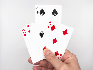 White male hand showing white plastic poker cards with four cards in the center on the image on a white background