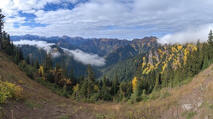 Naklejka premium Mountain vista showcasing autumn foliage and valley clouds.