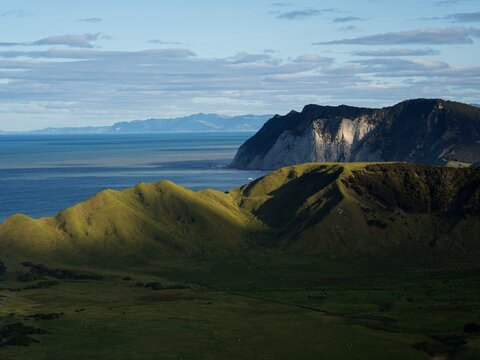 Landscape panorama of easternmost point of New Zealand, green grass coast vegetation, East Cape Lighthouse, Te Araroa