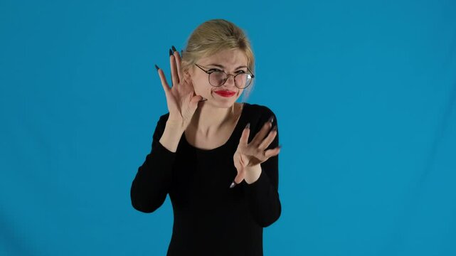 Female model expresses speech of companion with gestures holding other hand over ear. By wrinkling nose pretty blonde shows neglect slow motion