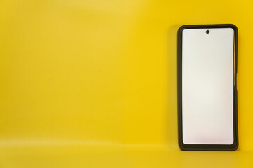 Smartphone with white screen isolated on yellow background