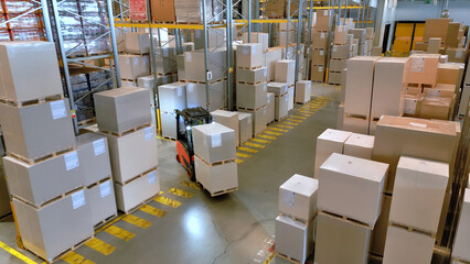 A vast warehouse reveals a maze of stacked boxes and crates, symbolizing global supply and logistics. A forklift navigates the aisles, highlighting the efficiency of warehouse operations. © wkproduction