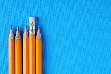 Many pencils on light blue background, top view. Space for text