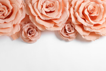 Beautiful pink paper flowers on white background, flat lay. Space for text