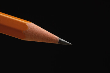 One sharp graphite pencil on black background, closeup