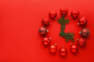 Clock made with Christmas decor and fir tree branches on red background, flat lay. Space for text