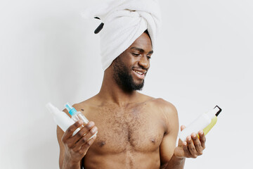 Man with a towel on his head holding shampoo and conditioner bottles, ready for a refreshing hair...