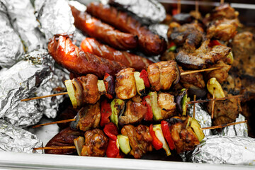 Savory skewers of grilled meat and veggies, plus sausages, perfect for outdoor dining with friends and family