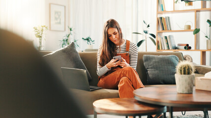 Woman, phone and typing with laptop, sofa and living room of home for ecommerce or online shopping. App, communication and computer with customer in apartment for bargain, retail sale or review