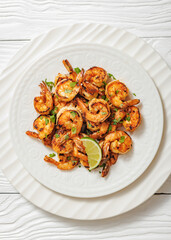 Grilled shrimp on a white plate with lime