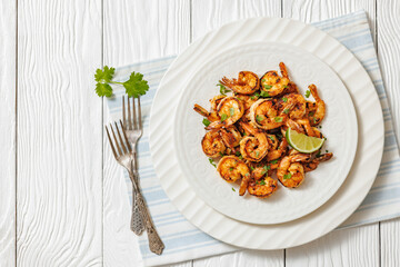 Grilled shrimp on a white plate with lime
