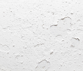 A white wall with a lot of cracks and holes