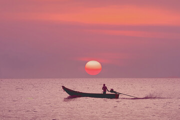 Tropical seascape is a classic traditional Thai Longtail boat set against the backdrop of a sunset...