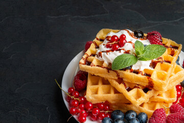 Waffles with fruits on dark background