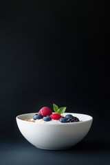 Minimalist yogurt breakfast bowl with crunchy granola and fresh berries, side view