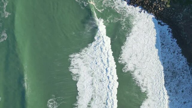 Waves crash on rocky Nazare coast, aerial view from Miradouro do Salgado