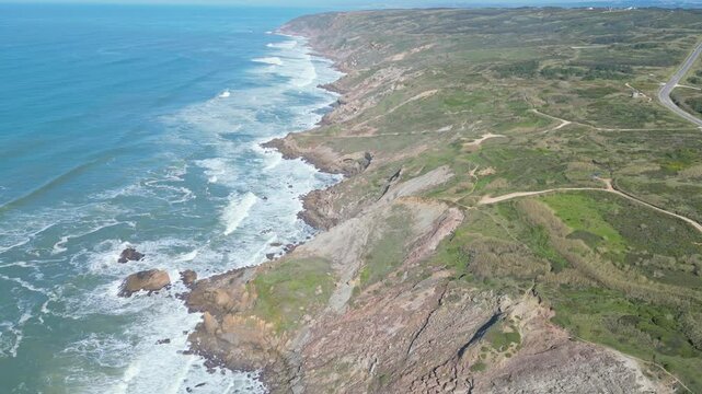 Cliffs and waves at Miradouro do Salgado on a sunny day in Nazar&eacute;, Portugal