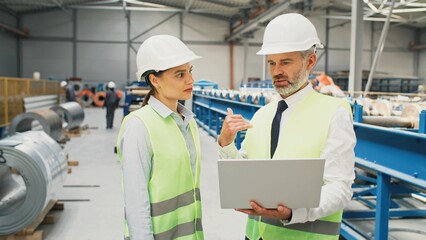 Male and female production engineers having discussion. Two manufactory workers communicating at...