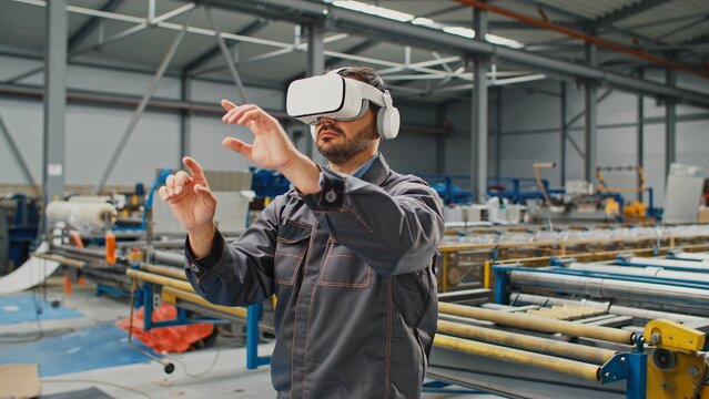 Hardworking man using virtual reality glasses in factory. Foreman moving hands on air while designing production project in digital reality. Developing industrial business with innovation technology. - Powered by Adobe