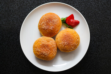 A handmade bombolone or bomboloni is an Italian-filled doughnut that is eaten as a snack or dessert. Selective focus.