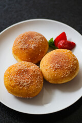 A handmade bombolone or bomboloni is an Italian-filled doughnut that is eaten as a snack or dessert. Selective focus.