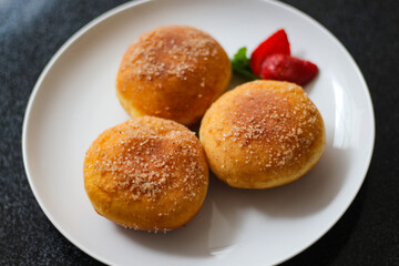 A handmade bombolone or bomboloni is an Italian-filled doughnut that is eaten as a snack or dessert. Selective focus.