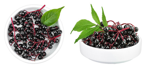 Ripe black elderberry or elder with green leaves in ceramic bowl isolated on a white background....
