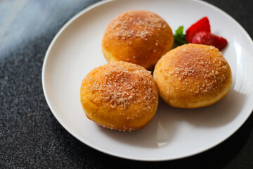 A handmade bombolone or bomboloni is an Italian-filled doughnut that is eaten as a snack or dessert. Selective focus.