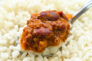 Chilli con carne with rice on spoon. Traditional Mexican food.