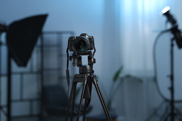 Professional video camera with tripod in modern studio