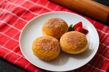 A handmade bombolone or bomboloni is an Italian-filled doughnut that is eaten as a snack or dessert. Selective focus.