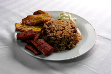 Traditional Costa Rican breakfast, rice and beans, called Gallo Pinto with eggs, tortilla, sausage and plantain.