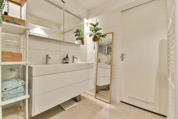 A sleek, modern bathroom featuring elegant fixtures, a large mirror, and stylish decor, creating a serene and inviting atmosphere.