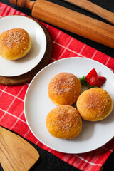 A handmade bombolone or bomboloni is an Italian-filled doughnut that is eaten as a snack or dessert. Selective focus.