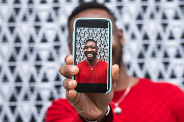 Happy black man taking selfie through smart phone