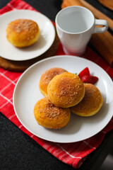 A handmade bombolone or bomboloni is an Italian-filled doughnut that is eaten as a snack or dessert. Selective focus.