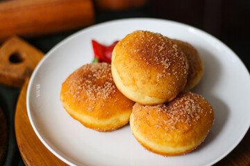 A handmade bombolone or bomboloni is an Italian-filled doughnut that is eaten as a snack or dessert. Selective focus.