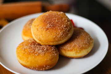 A handmade bombolone or bomboloni is an Italian-filled doughnut that is eaten as a snack or dessert. Selective focus.