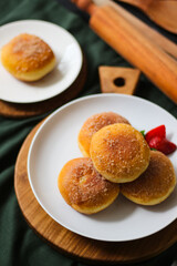 A handmade bombolone or bomboloni is an Italian-filled doughnut that is eaten as a snack or dessert. Selective focus.