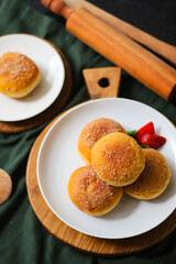 A handmade bombolone or bomboloni is an Italian-filled doughnut that is eaten as a snack or dessert. Selective focus.