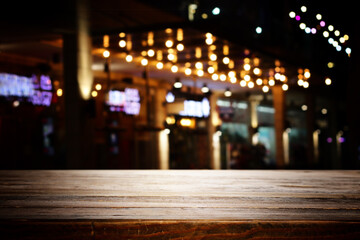 background Image of wooden table in front of abstract blurred restaurant lights
