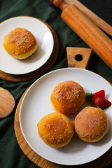 A handmade bombolone or bomboloni is an Italian-filled doughnut that is eaten as a snack or dessert. Selective focus.