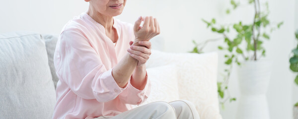 腕が痺れる高齢者女性.