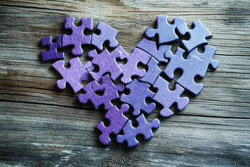 Purple heart puzzle pieces scattered on wood a poignant image of love and loss