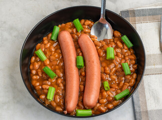 hot dogs  on baked beans top with green onions