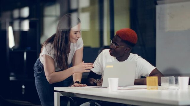 Creative, energetic business woman gives work assignments to new African American employee.