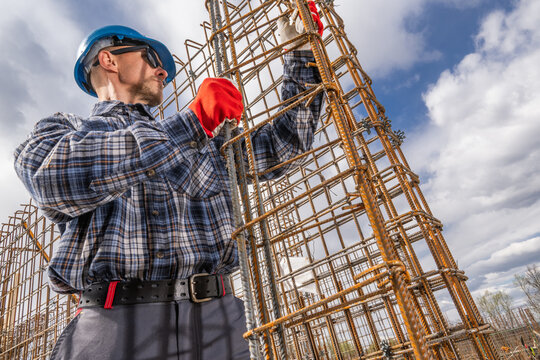Construction Worker Assembling Steel Framework on a Site